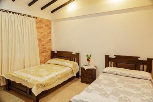 1 dormitorio con 2 camas y ventana en Finca la Flor del Café, en Quimbaya