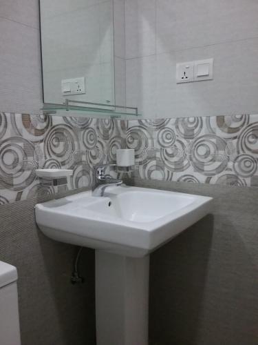 une salle de bain avec un lavabo blanc et un miroir dans l'établissement Wick's Apartment, à Hikkaduwa
