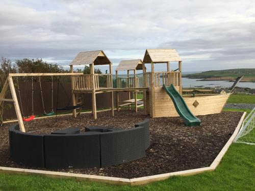 a playground with wooden play equipment and a slide at Ocean View,Kinsale, Hosted by Exquisite holiday homes, sleeps 22 in Kinsale