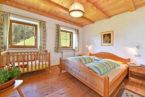 a bedroom with a bed and a crib at Obererhof in SantʼAndrea in Monte