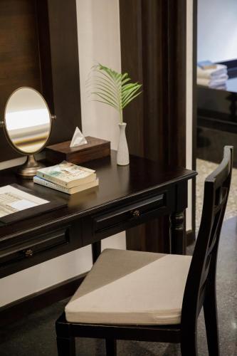 a desk with a chair and a table with a plant on it at Thai Akara - Lanna Boutique Hotel in Chiang Mai