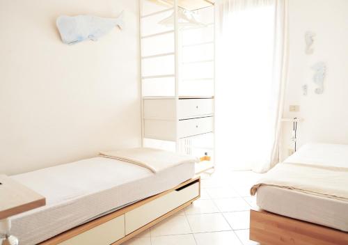 2 letti in una camera da letto con pareti bianche di Sunny Apartment On The Sea a Cavallino-Treporti