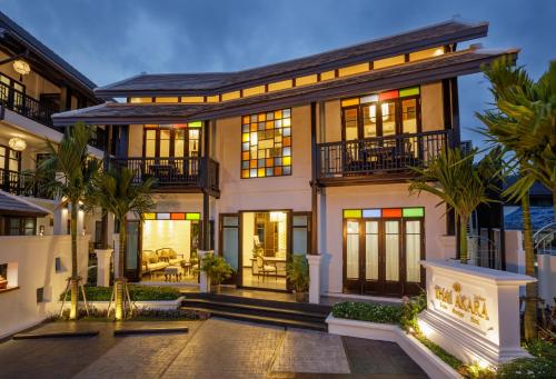 a large house with palm trees in front of it at Thai Akara - Lanna Boutique Hotel in Chiang Mai