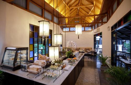 a restaurant with tables and chairs and a large window at Thai Akara - Lanna Boutique Hotel -SHA Extra Plus in Chiang Mai