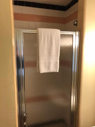 a towel hanging on a shower door in a bathroom at The Walpole Motel in Walpole