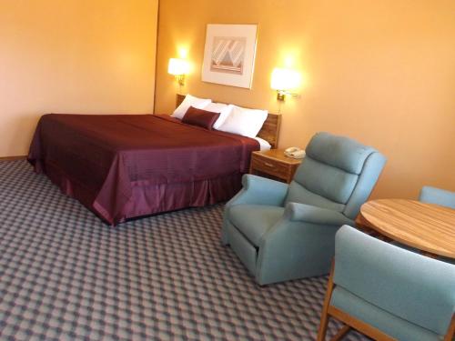 a hotel room with a bed and a chair at Tristar Inn Xpress in Tucumcari