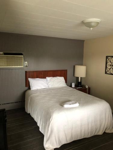 a bedroom with a large bed with a white comforter at The Walpole Motel in Walpole