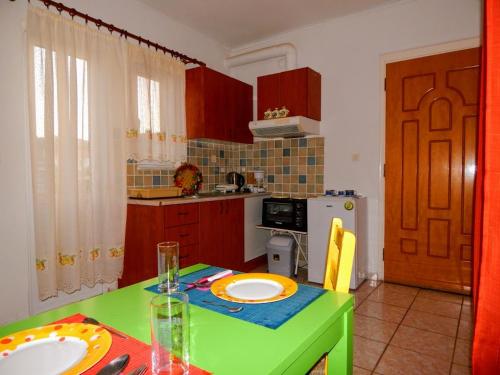 トリポリスにあるSmall country apartment in Tripoliのキッチン(グリーンテーブル、皿付)