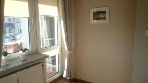 a living room with two windows and a window sill at Apartament Mieszka in Kołobrzeg