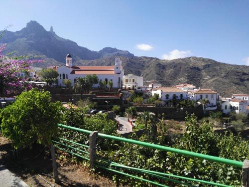 un village avec une église et des montagnes en arrière-plan dans l'établissement Alojamientos Nicasio, à Tejeda