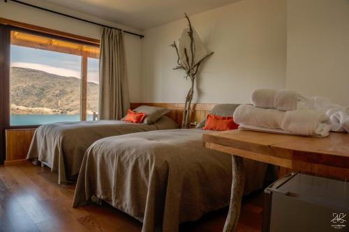 a hotel room with two beds and a window at Mallin Colorado Ecolodge in Aldana