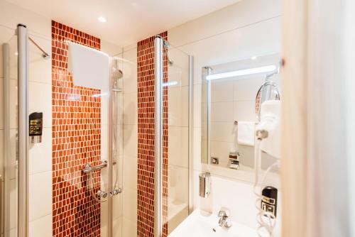 a bathroom with a shower and a sink at Erlebnishotel "Zur Schiffsmühle" GmbH in Höfgen