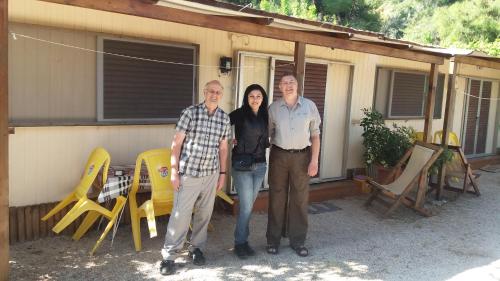 a group of three people standing in front of a house at XeniCamp & Bungalows in Tolo