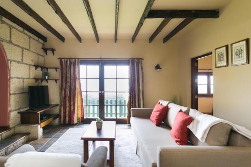 a living room with a couch and a tv at Casitas Las Uvas y las Viñas in Los Realejos