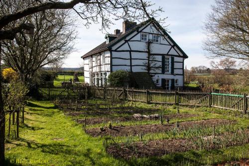 een oud huis in een veld met een hek bij B&B Einrade in Vaals