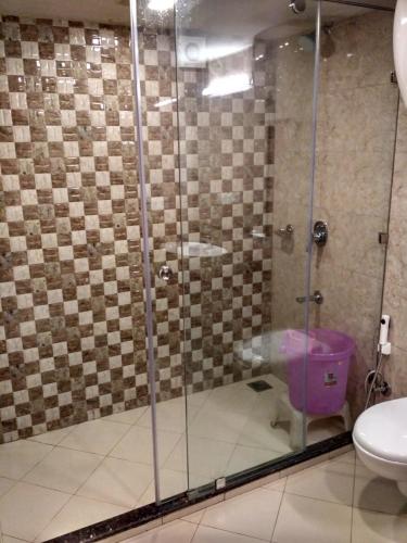 a bathroom with a glass shower with a toilet at Hotel Hamers International in Mussoorie