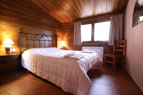 a bedroom with a bed in a wooden cabin at Apartaments Piteus Casa Dionis in Sant Llorenc de Morunys