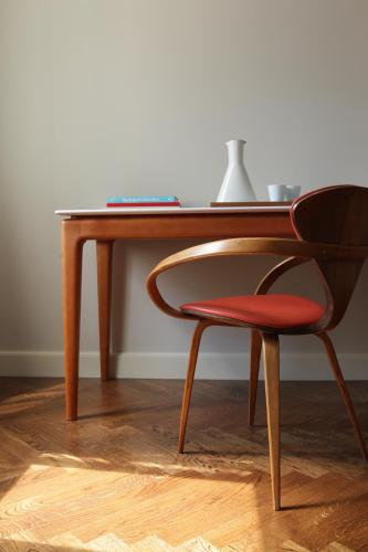 a wooden desk with a chair next to a table at Between Us Bed and Breakfast in Warsaw