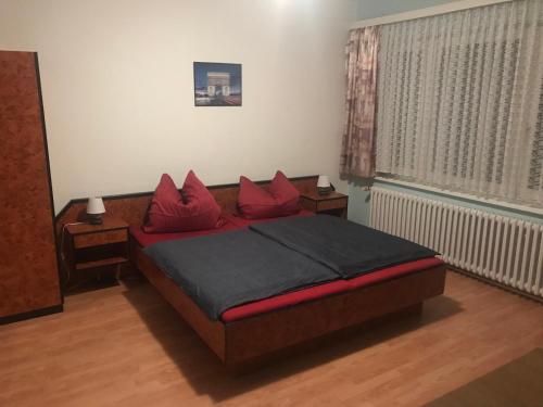 Un dormitorio con una cama con almohadas rojas. en Dos Gauchos, en Grünheide