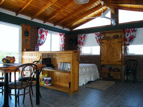 um quarto com uma cama, uma mesa e cadeiras em Cabañas Doña Itati em Villa Carlos Paz