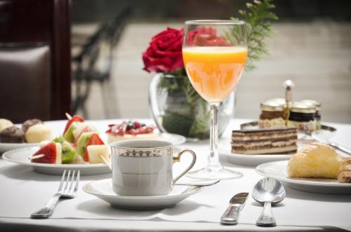 马德普拉塔圣珍妮精品酒店及Spa中心的桌子上摆着几盘食物和一杯橙汁