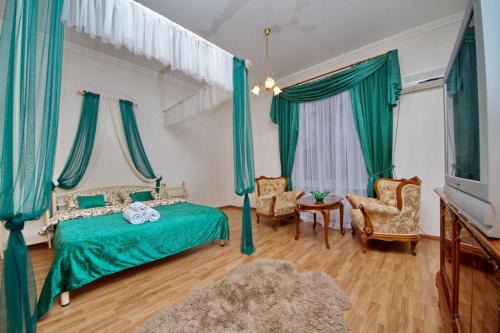 キーウにあるЛютеранская 4のベッドルーム1室(緑のベッド1台、椅子2脚付)