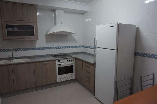 リバデオにあるDuplex Ribadeoのキッチン(白い冷蔵庫、シンク付)