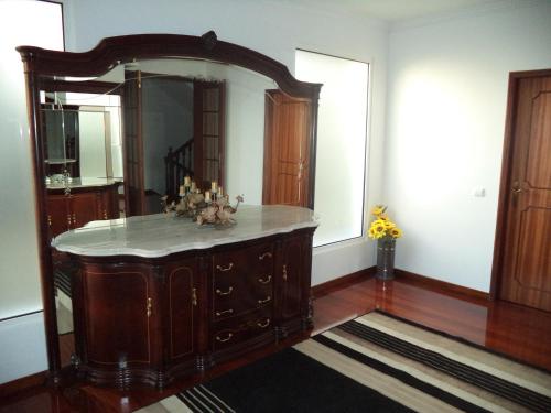 フンシャルにあるVilla Palmeirasの大きな鏡と木製ドレッサーが備わるお部屋
