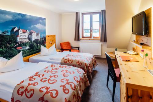a hotel room with two beds and a desk at Erlebnishotel "Zur Schiffsmühle" GmbH in Höfgen