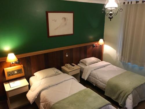 um quarto com duas camas e uma parede verde em Residencial Pantanal Vila Mariana em São Paulo