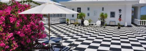 a patio with a black and white checkered floor and an umbrella at Jamaica Palace Hotel in Port Antonio