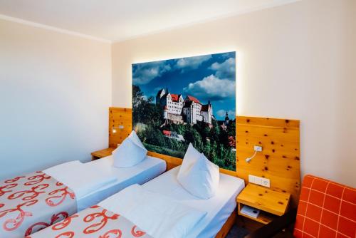 a hotel room with two beds and a painting on the wall at Erlebnishotel "Zur Schiffsmühle" GmbH in Höfgen