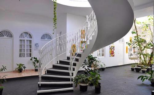 a white staircase in a building with potted plants at Jamaica Palace Hotel in Port Antonio