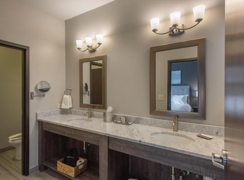 a bathroom with two sinks and two mirrors at Valhalla Resort Hotel in Helen