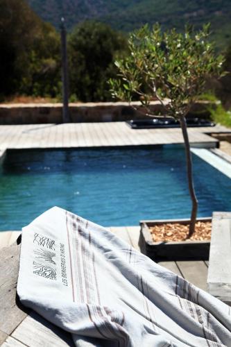 - une serviette assise sur une table à côté de la piscine dans l'établissement Les Bergeries d'Arone, à Piana
