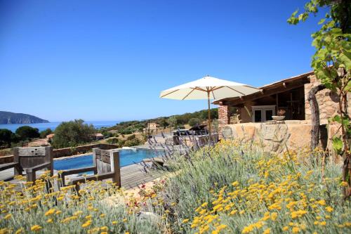 uma vista para uma casa com um guarda-sol e uma piscina em Les Bergeries d'Arone em Piana