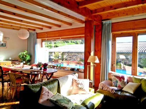 a living room with couches and a dining room with a table at Chalet "Rec dels Noguers" in Castellciutat
