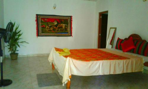 a bedroom with a bed with a red blanket on it at River Retreat Sigiriya in Sigiriya