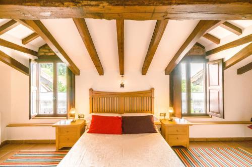 ein Schlafzimmer mit einem großen Bett und zwei Fenstern in der Unterkunft Posada La Charola in Lamadrid