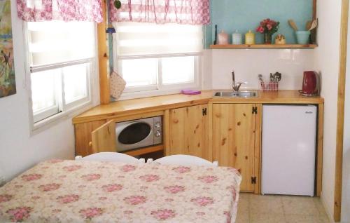 a small kitchen with a table and a microwave at Jordan Valley one room apartment in Menaẖemya