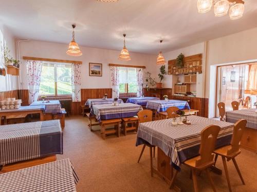 Hotel Flora Dolní Mísečky في Dolni Misecky: غرفة طعام مع طاولات وكراسي زرقاء