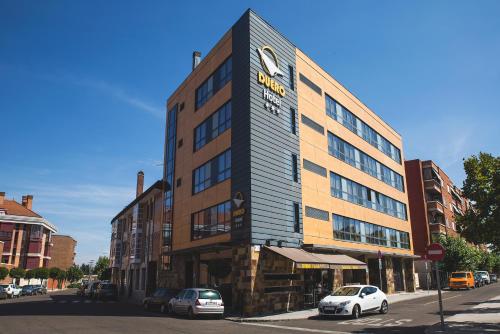 ein Gebäude auf einer Straße mit davor geparkt in der Unterkunft Hotel Duero in Laguna de Duero