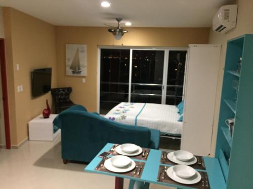 a living room with a bed and a couch and a table at Playa y alberca en Zona Marina in Mazatlán