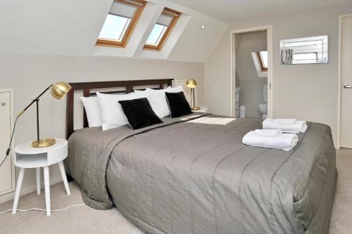 a bedroom with a large bed with a lamp and a table at Regents 94B - Christchurch Holiday Homes in Christchurch