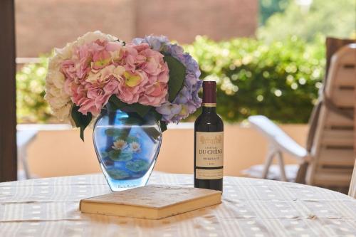 a bottle of wine and a vase of flowers on a table at Ferienwohnung Isabella in Ascona