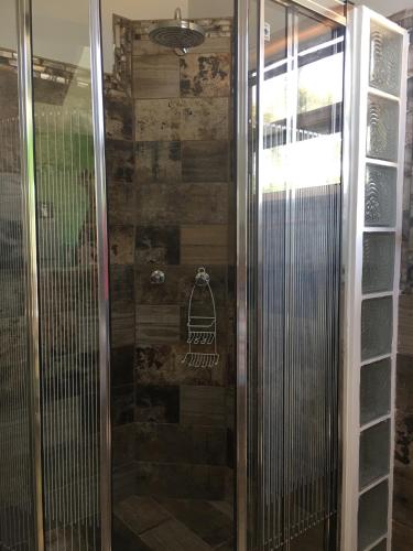 a shower with a glass door with a sign on it at Hidden Treasure Vacation Home Blue Bay Cottage in Caye Caulker