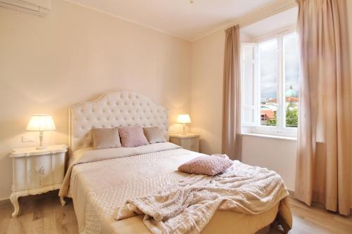 a bedroom with a white bed with a window at LUCCA IN CHIC - No Ztl, Free Parking, Priv Bath, Old City 550m in Lucca