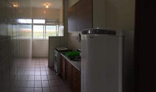 a small kitchen with a sink and a refrigerator at Residencial Baia Blanca in Florianópolis