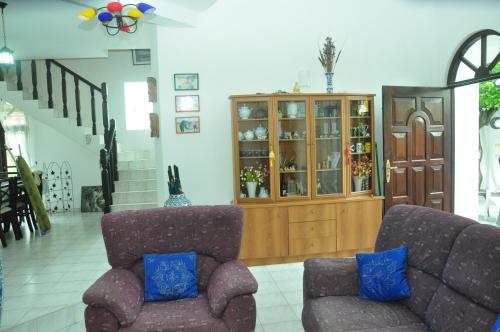a living room with two chairs and a cabinet at Bon Accord Mirissa in Mirissa