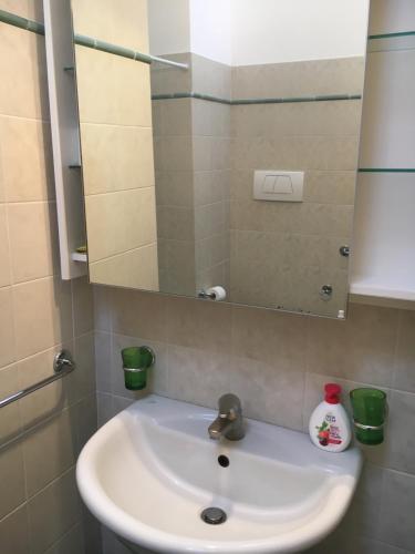 biała umywalka w łazience z lustrem w obiekcie Residence IL PORTO w mieście Fano